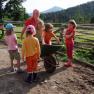 Am Bauernhof kommt nie Langeweile auf!, © zVg Kinder spielen mit einer Schubkarre auf einem Bauernhof.