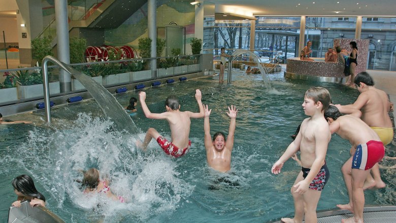 Aquacity St. Pölten, © Aquacity St. Pölten Kinder spielen und planschen in einem Hallenbad mit Wasserspielen.