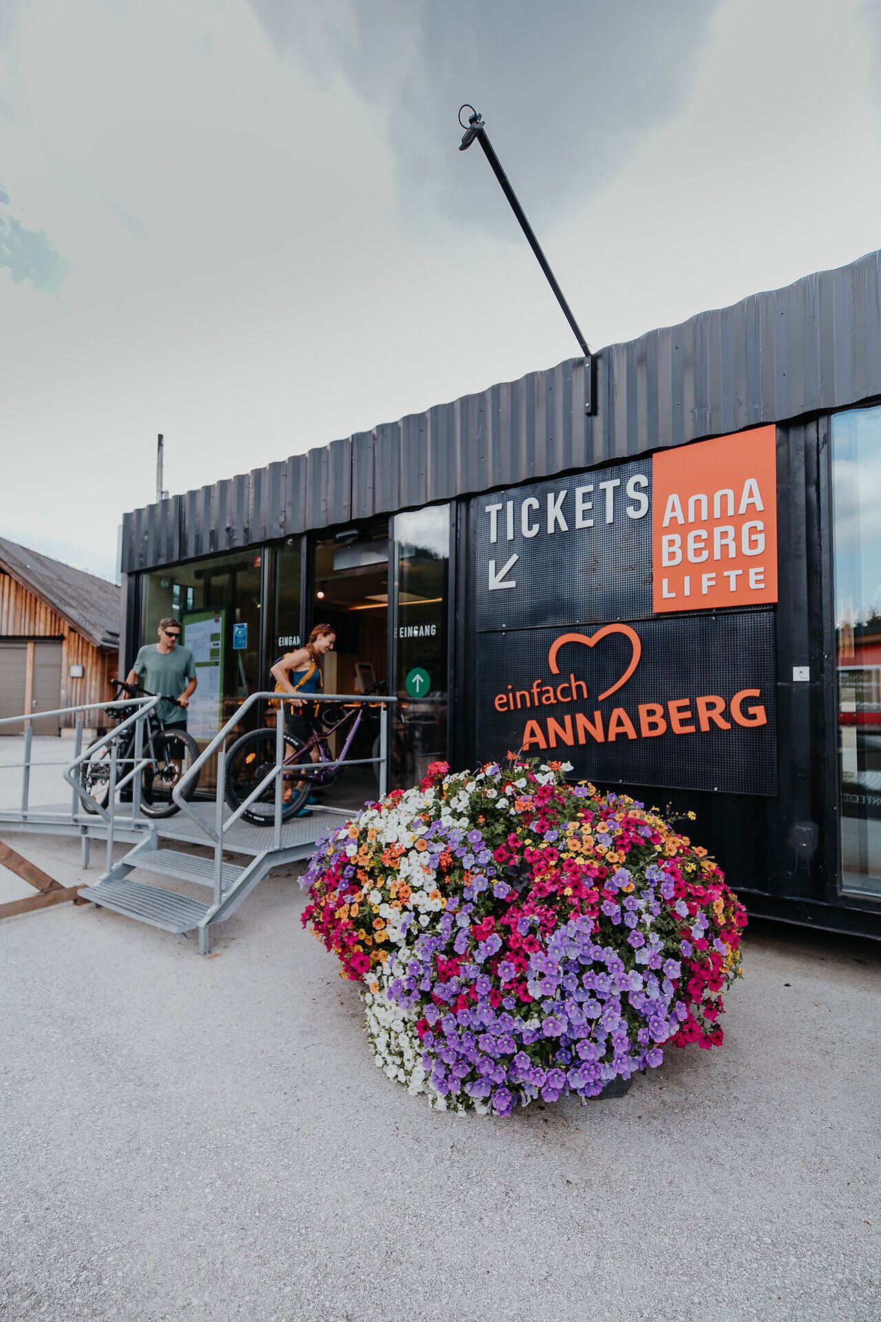 Ein Mann und eine Frau erkunden den Bikeverleih der Annaberger Lifte, der sich direkt im Ticketpoint der Annaberger Lifte befindet. Im Verleihbereich sind Mountainbikes und Kinderräder ausgestellt, sodass von klein bis groß für jeden das passende Fahrrad verfügbar ist.