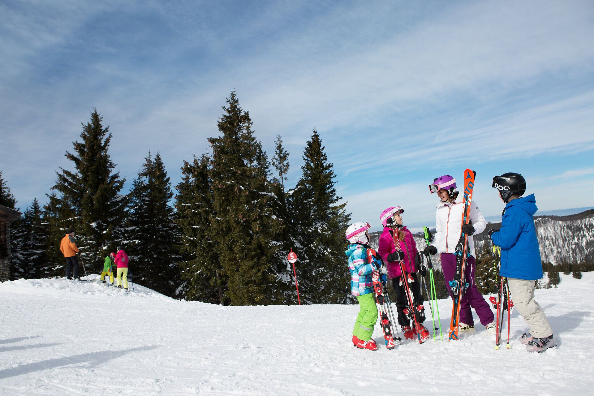 Die strahlende Wintersonne taucht die verschneite Landschaft in ein warmes Licht, während fröhliche Kinder mit ihren Skiern die Pisten hinunter sausen. Umgeben von majestätischen Tannen und der frischen Bergluft, erleben die Familien unvergessliche Abenteuer im Schnee.