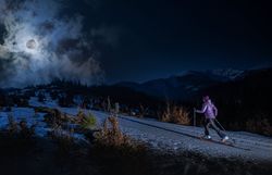 Unter dem strahlenden Mondlicht gleitet ein Skifahrer über die glitzernde Schneedecke, umgeben von der majestätischen Berglandschaft. Die ruhige Nachtluft ist erfüllt von der frischen Kälte des Winters, während die schneebedeckten Gipfel im Hintergrund geheimnisvoll leuchten. Ein unvergessliches Erlebnis für alle Wintersportbegeisterten, die die Stille der Nacht in den Bergen genießen möchten.