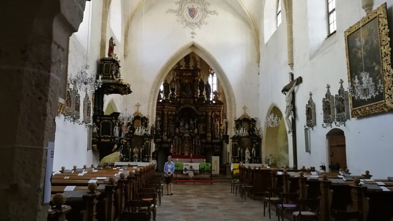 Interior view of a pilgrimage church with altar, benches and religious works of art.