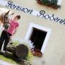A woman stands with a horse in front of a building labeled 'Pension Bodenhof'.