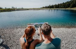 Ein Mann und eine Frau erkunden die Umgebung rund um den Speichersee am Hennesteck am Annaberg mit dem Fahrrad. Sie sind auf den Wegen rund um den See unterwegs und entdecken dabei die alpine Landschaft mit ihren Bergen, Wiesen und Aussichtspunkten.