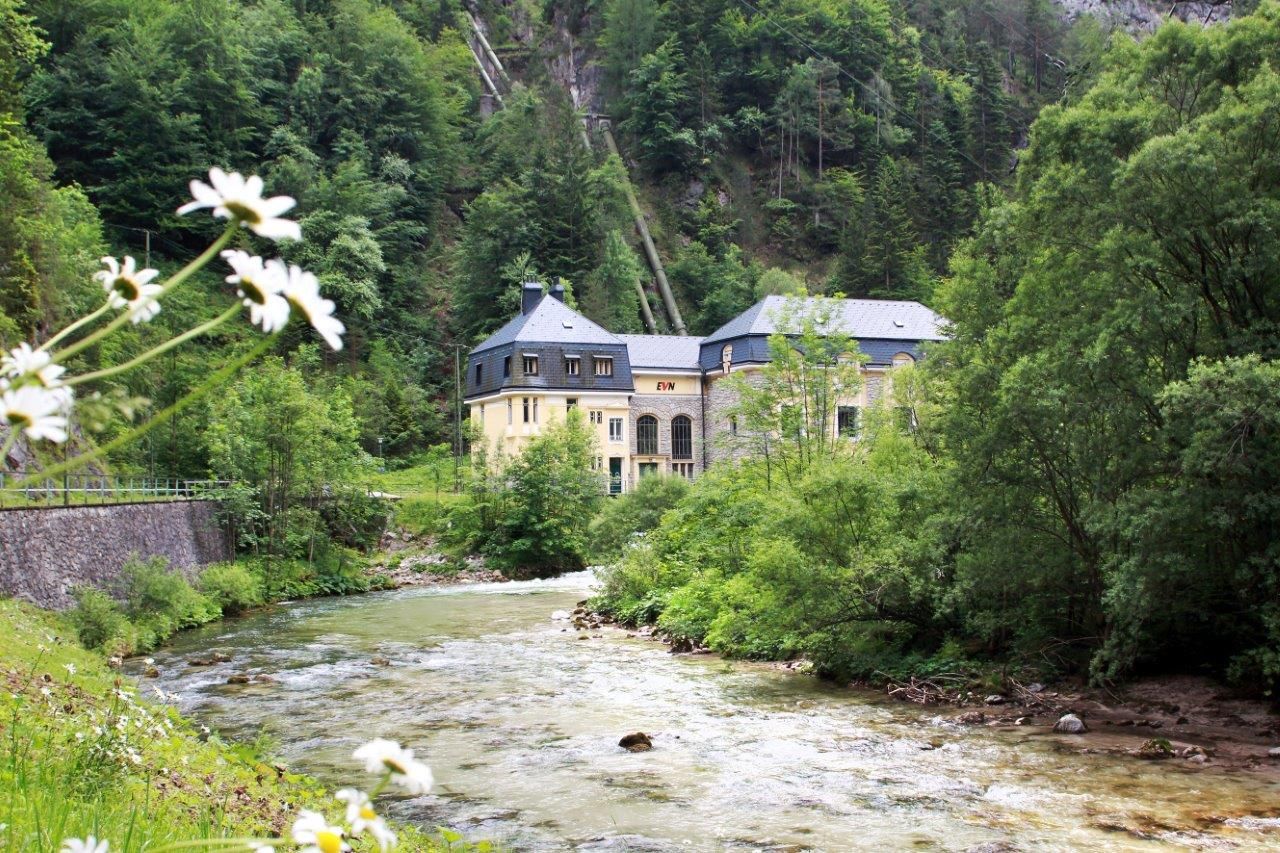 EVN-Kraftwerk Wienerbruck in grüner Landschaft mit Fluss.